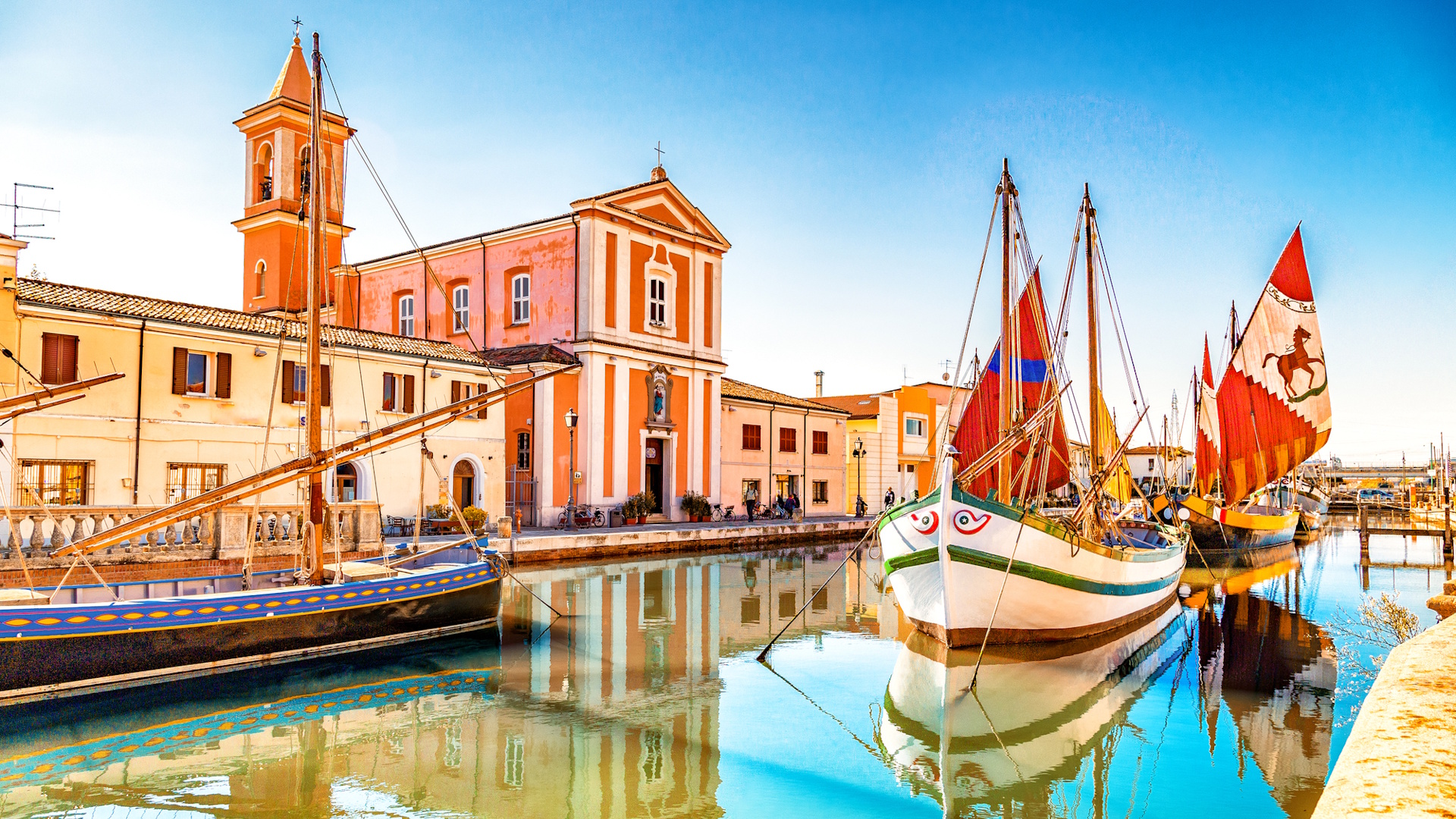 Church and ancient saiboats on Leonardesque gat in Cesenatico in Italy